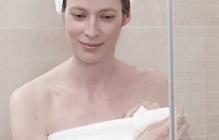 Una mujer después de ducharse, envuelta en una toalla, y una toalla en la cabeza como turbante.
