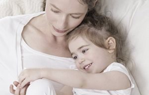 Una madre con el hijo acurrucados.