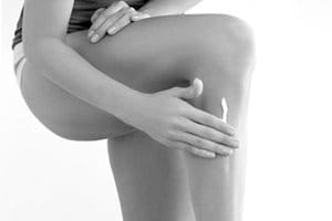 Mujer tocándose la pierna izquierda